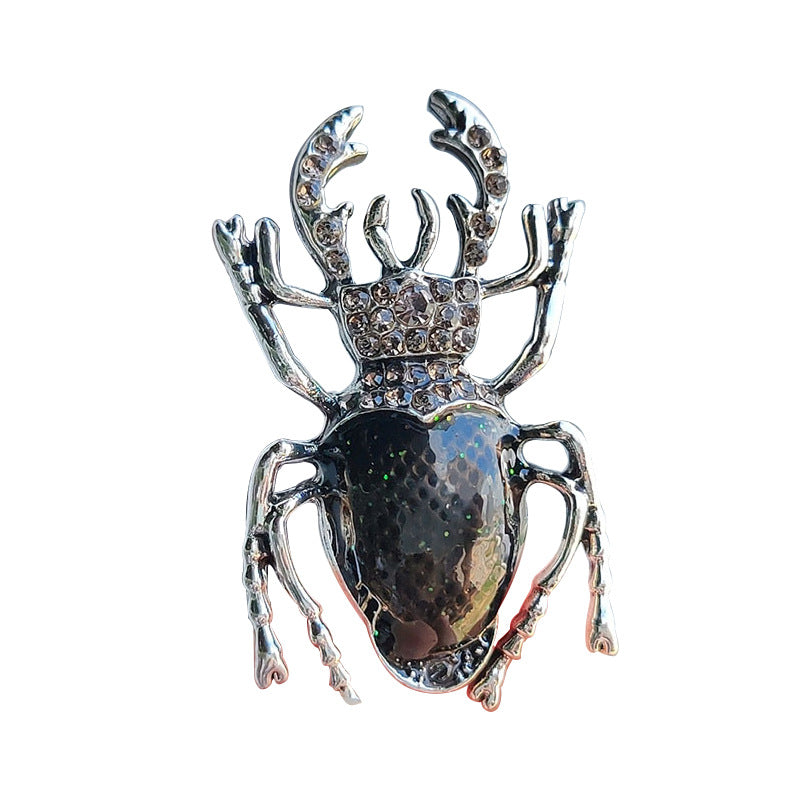 Vintage Beetle Brooch sitting on a fashion magazine