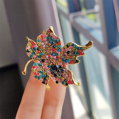Vintage leaf brooch with colourful crystals front view