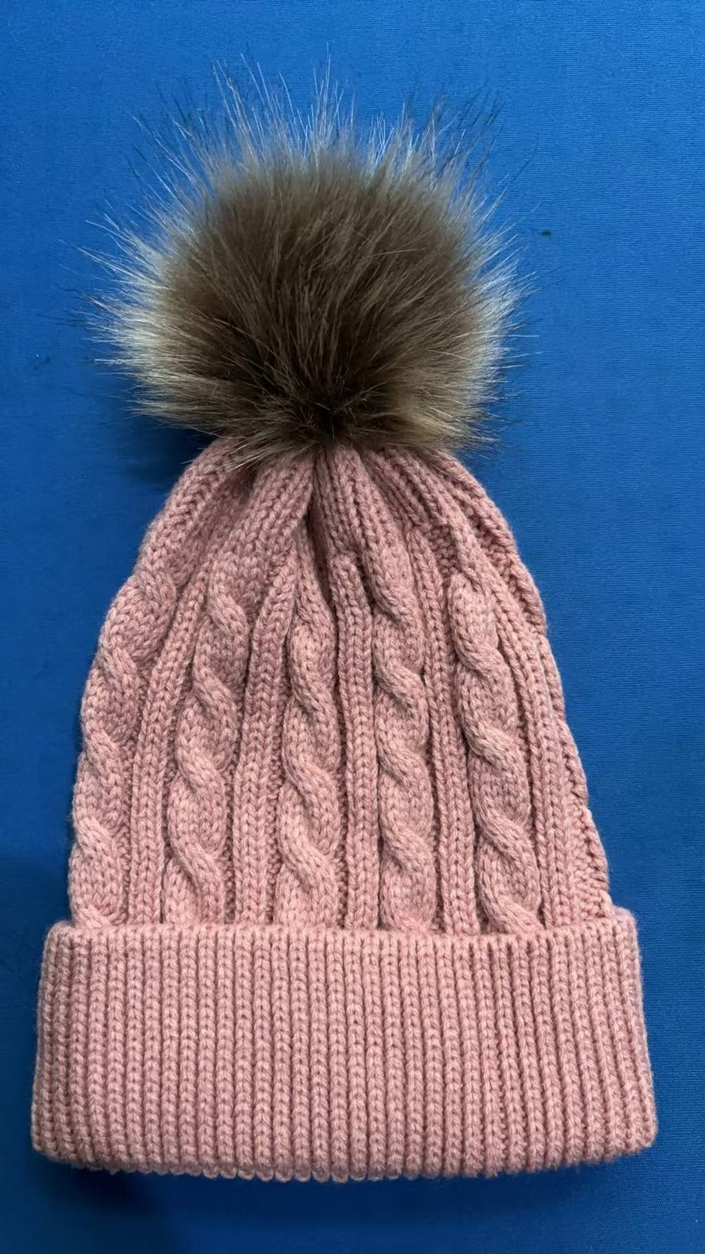 Navy blue knit beanie featuring a pom pom