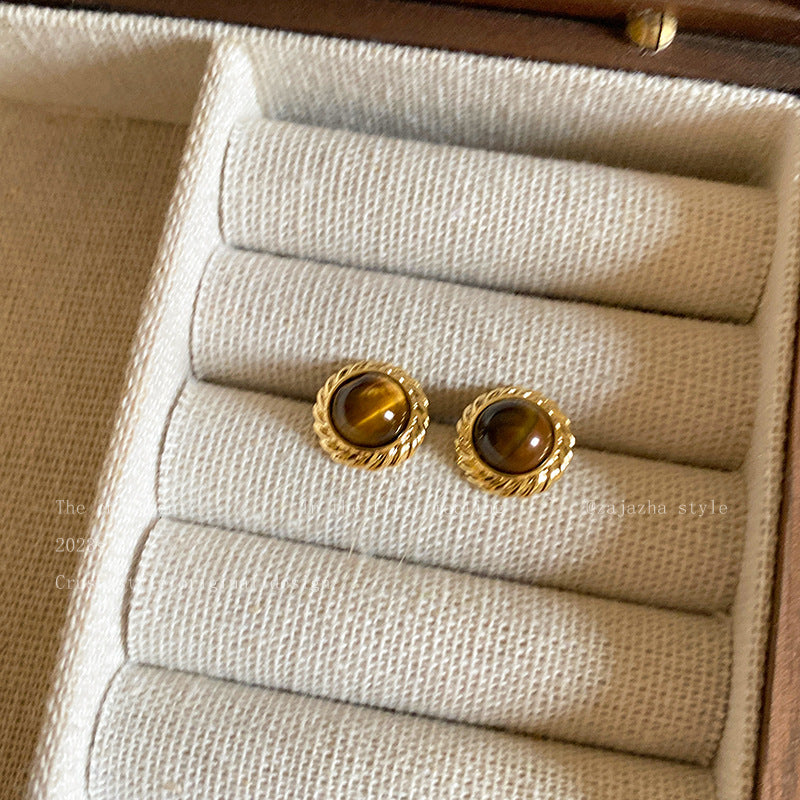 Close up of metal and tiger eye stone earrings