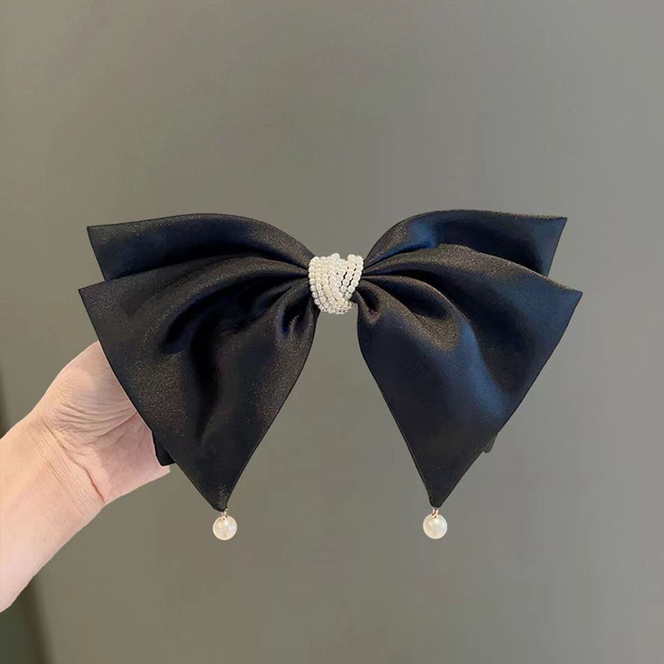 Black satin bow clip in use with hair